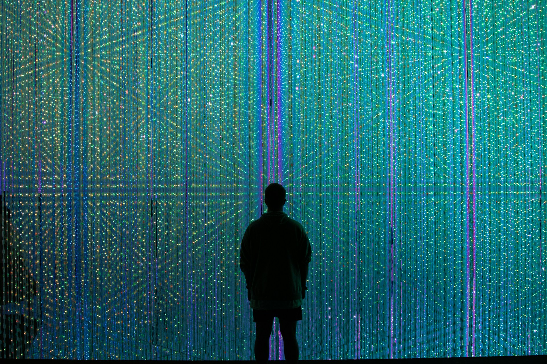 A silhouette of a man standing inside a sparkling prism construction.